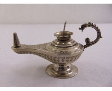A white metal Middle Eastern oil lamp of Aladdin form with serpent handle on circular spreading base