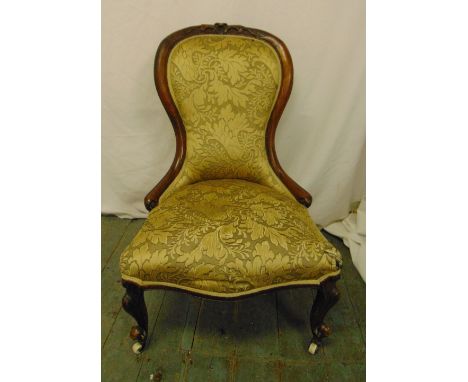 A Victorian mahogany upholstered balloon back chair on scroll legs with original castors