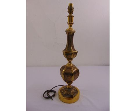 A panelled baluster form brass table lamp on raised hexagonal base and circular plinth