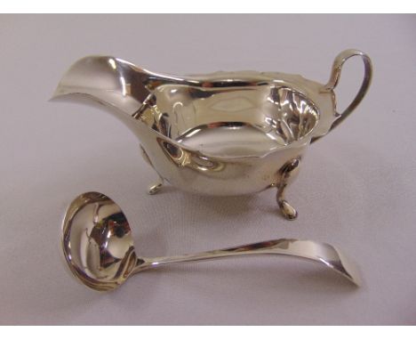 A silver sauce boat, oval, cut edge with loop handle on three scroll legs, Sheffield 1935 and a sauce ladle, Sheffield 1959