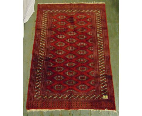 A Middle Eastern wool carpet red ground with repeating geometric forms and stylised border, 179 x 124.5cm