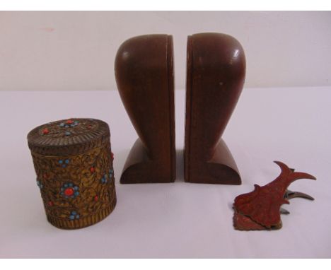 A pair of ethnic carved wooden bookends, a cylindrical filigree metal box set with stones and an enamel letter clip (3)