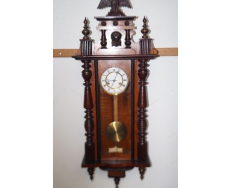 Vienna style wall clock in mahogany and rosewood, enamel dial with Roman numerals, surmounted with a stylised eagle finial  