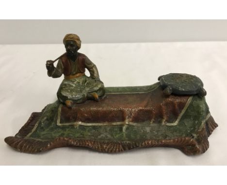 A vintage cold  painted inkwell and pen rest in shape of Turkish gentleman sitting on a rug. Complete with ceramic liner ( a/