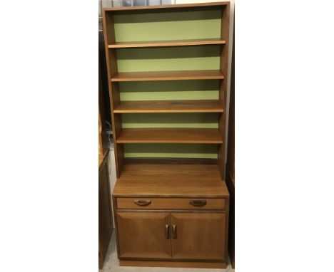 A vintage teak display unit in 2 parts. 2 door cupboard with interior shelf under central door below a large shelfing unit wi