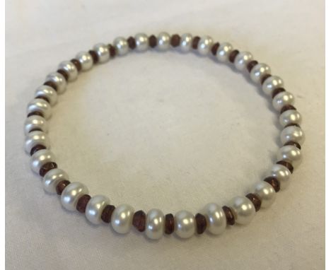 A freshwater pearl and garnet bangle.  