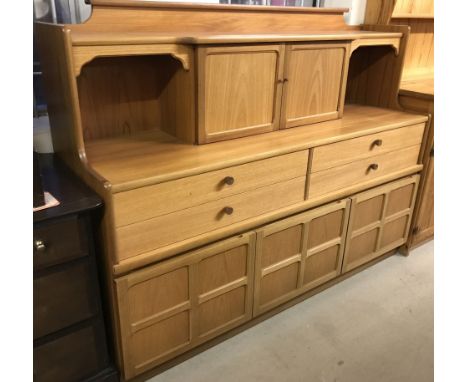 A vintage Nathan teak sideboard. With 3 cupboards and 4 drawers to base and 2 door cupboard with glass interior shelf to top.