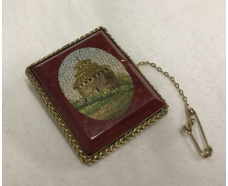 A 9ct gold mounted rectangular ceramic micro mosaic brooch with safety chain. a/f Approx. 2.5 x 3cm.