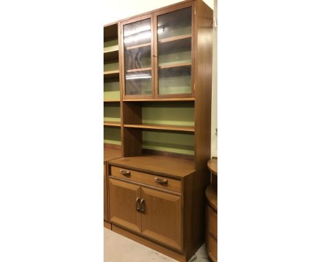 A vintage teak display unit in 2 parts. Base unit has 2 door cupboard with interior shelf under a 2 compartment drawer. Top u