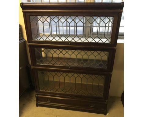 A Globe Wernicke style 3 compartment bookcase. With lower drawer and leaded glass fronts. Approx. 87cm wide x 120cm tall.