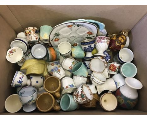 A box of mixed vintage and novelty egg cups. To include examples from Spode, Royal Doulton, Shelley, Poole and Royal Crown De