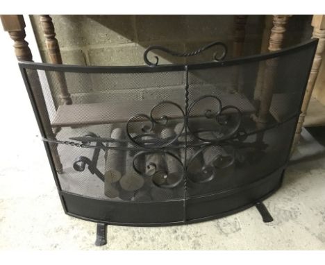 A black wrought iron fireguard and log basket. Together with a poker and pair of fire tongs. 