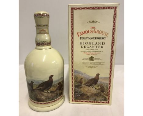 A sealed and boxed bottle of Famous Grouse finest Scotch whisky in a Highland Decanter. Wade ceramic decanter gilded with 24 