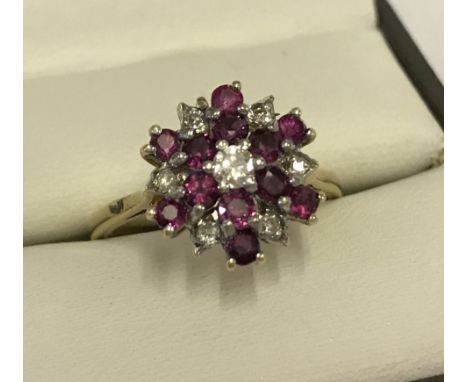 An 18ct gold diamond & ruby cluster ring. 7 diamonds (approx. 0.3ct) & 12 rubies (approx. 0.6ct). Total weight approx. 4.9g. 