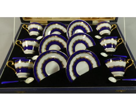 A Cased Coffee Set Comprising Six Cup and Saucers having Blue and Gilt Decoration with Six Matching Silver and Enamel Spoons.