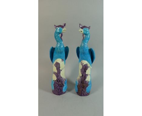 A Pair of Ceramic Oriental Phoenix, In Blue, Purple and Cream Enamels. On Naturalistic Bases Modelled with Flowers. 30cms Tal