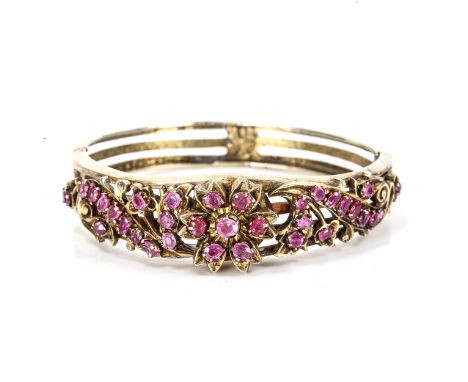 A Victorian ruby floral hinged bangle, unmarked silver settings with pierced openwork decoration, setting height 16.5mm, inte