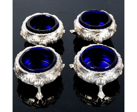 A set of 4 Edwardian silver salt cellars, relief embossed floral decoration with blue glass liners, by William Hutton & Sons 