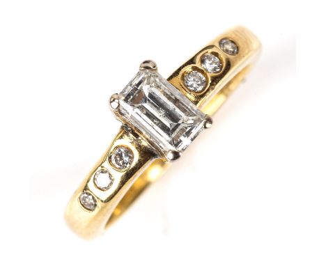 An 18ct gold solitaire diamond ring, set with rectangular step-cut diamond and modern round brilliant-cut diamond shoulders, 