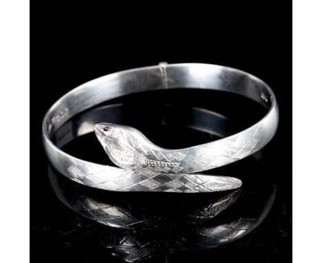 A late 20th century silver and garnet figural snake hinged bangle, engraved decoration, by Fred Manshaw Ltd, hallmarks London