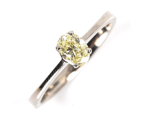 A modern 18ct white gold 0.5ct fancy yellow solitaire diamond ring, plain 4-claw setting with oval brilliant-cut diamond, cla