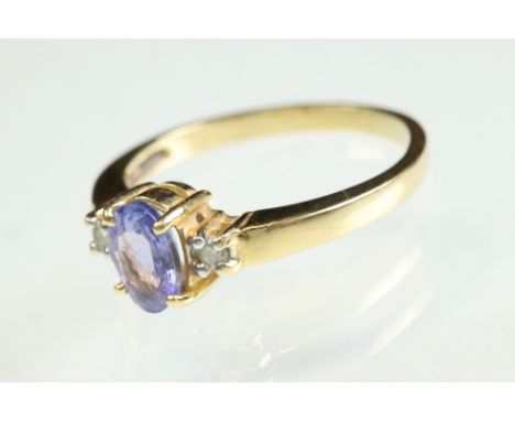 Tanzanite and diamond 18ct yellow gold ring, the oval mixed cut tanzanite measuring approx 7mm x 5mm, claw set, a small round