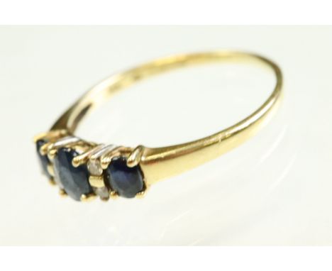 Sapphire and diamond 18ct yellow gold ring, three graduated oval mixed cut sapphire with four small round brilliant cut diamo