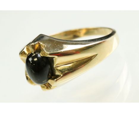 Star diopside 9ct yellow gold gents ring, the oval cabochon cut black diopside measuring approx 8.5mm x 7mm, displaying a fou