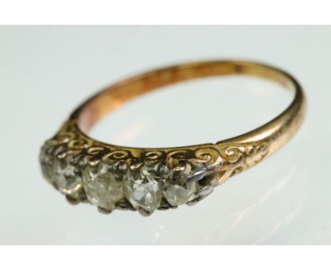 Victorian diamond unmarked yellow gold five stone ring, five graduated old cushion cut diamonds, silver claw settings, scroll