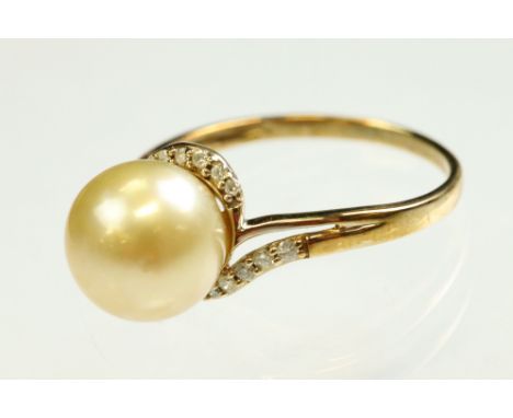 Pearl and diamond 9ct yellow gold ring, the spherical yellow pearl to the centre, diameter approx 10mm, the crossover shoulde