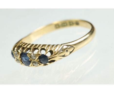 Edwardian sapphire and diamond 18ct yellow gold ring, three graduated mixed cut blue sapphire, the central sapphire measuring