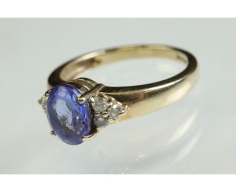 Tanzanite and diamond 9ct yellow gold ring, the oval mixed cut tanzanite measuring approx 8.5mm x 6.5mm, claw set, three smal