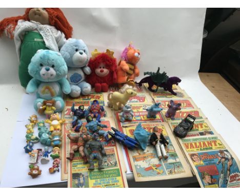 A box of various toys including a Cabbage patch doll , Care Bears, Masters of the universe and some comics