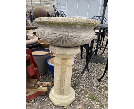 A RECONSTITUTED STONE PLANTER ON A PEDESTAL BASE 