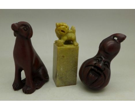 A carved netsuke, a carved figure of a dog and a hardstone seal (3)
