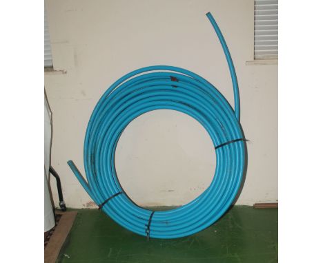 A roll of blue plastic water pipe