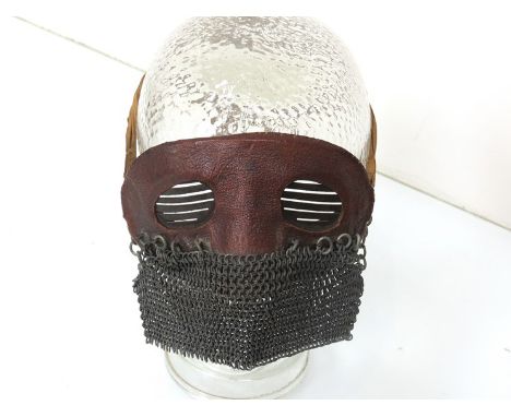 A WWI tank splatter mask, the medium brown leather eye piece with metal shuttering chained face protector. Original tying str