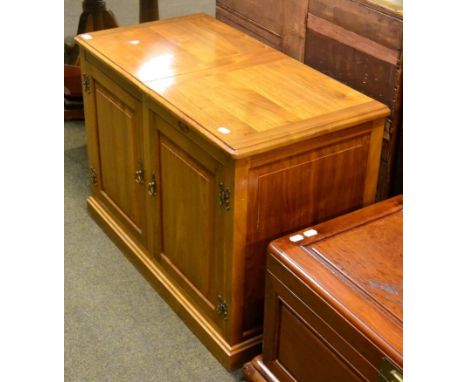 A Peter ''Dolphinman'' Daynes walnut two door television/music cabinet, with part hinged top revealing a shelf, the fixed hal