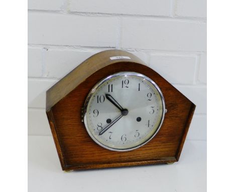 An oak cased Art Deco mantle clock with silvered dial and Arabic numerals 