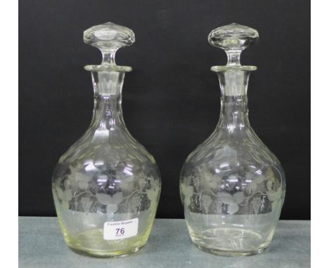 A pair of fruit and vine etched decanter and stoppers, 26cm high