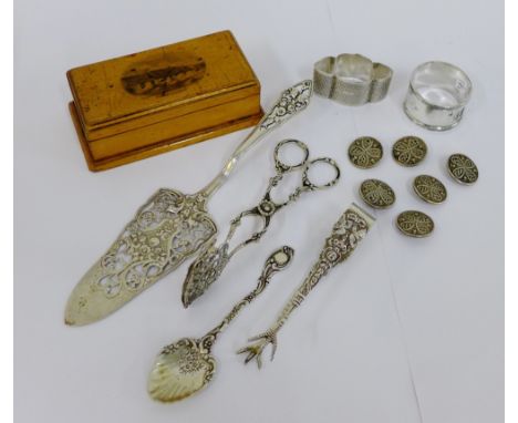 A mixed lot of silver items to include two napkin rings, pastry slice, tongs and a teaspoon together with a set of six white 