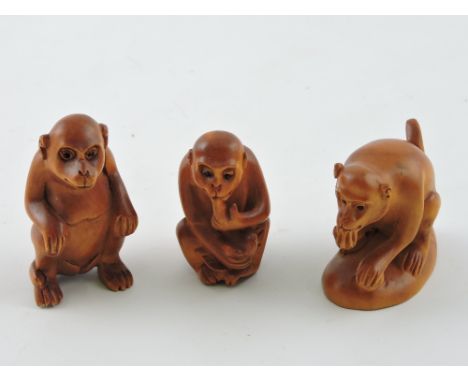 Three hardwood netsuke modelled as monkeys.
