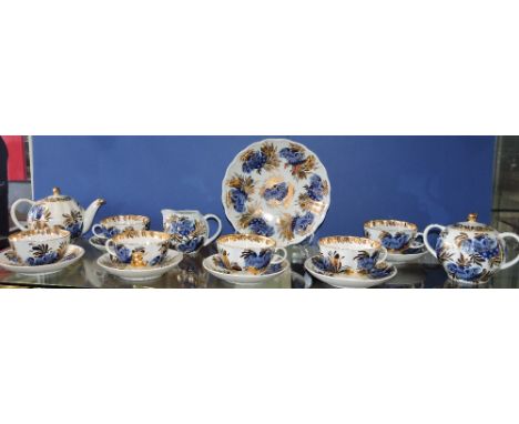 A 20th Century Russian porcelain 16 piece tea service, six settings, decorated with exotic birds in blue glaze among gilded l