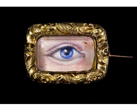 A Georgian lovers eye miniature brooch, painting in oils of a blue eye, applied gold foliate surround, glazed, dimensions app
