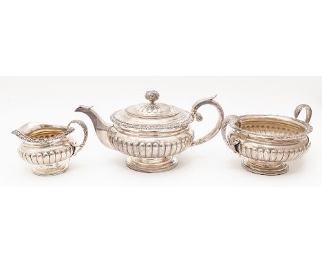 A George III Scottish silver three piece tea service comprising teapot, sugar bowl and milk jug, with floral border above lob