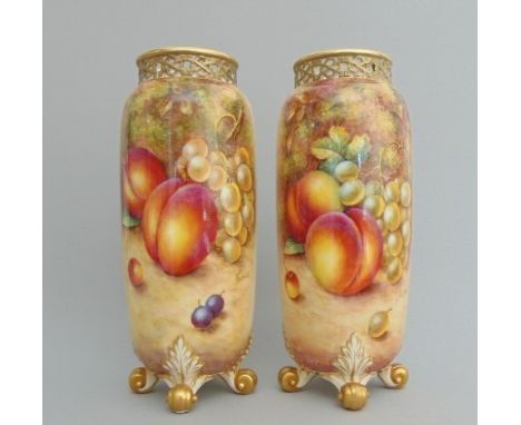 A pair of Royal Worcester G42 shaped vases, with pierced neck and painted with fruit signed by Freeman, 20th Century black ma