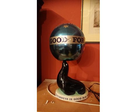 A Carltonware Guinness advertising lamp modelled as a sealion balancing a spherical ball lampshade with "Guinness if good for