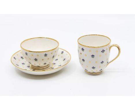 A Derby trio comprising tea Bowl, coffee Cup and saucer, pinted with gold stars and enamelled Angouleme sprigs, gilt dentil r