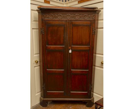 A 19th Century oak free standing corner cupboard,&nbsp;the cornice carved with rosettes and roundels, fitted&nbsp;with two th