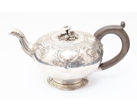 A George III silver Bachelor's Teapot, chased with floral scrolls, the hinged cover with flower finial,&nbsp; ebony C-scroll 